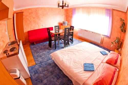 een kleine kamer met een bed en een tafel bij Guest House Pikapolonca in Maribor