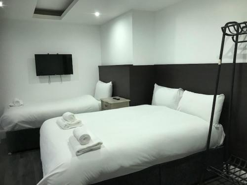 a hotel room with two beds and a flat screen tv at The Picture House Apartments in Liverpool