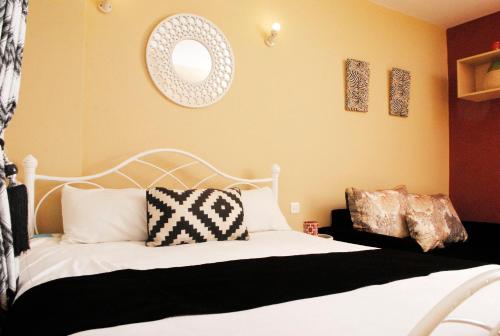 a bedroom with a white bed and a mirror at WEST SUITES SHERRY HOMES in Nairobi
