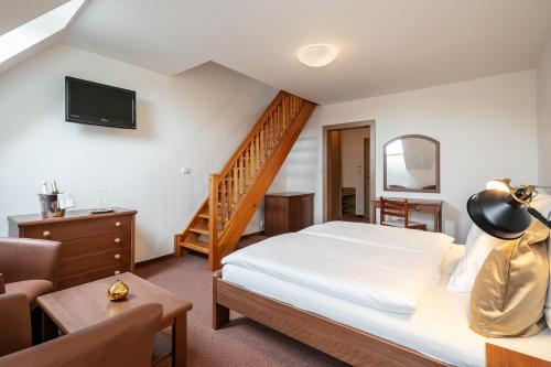 a hotel room with a bed and a staircase at Pytloun Wellness Hotel Hasištejn in Místo