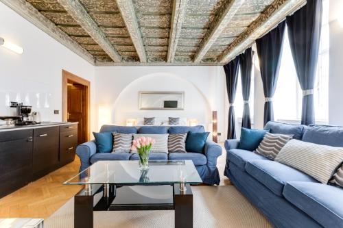 ein Wohnzimmer mit blauen Sofas und einem Tisch in der Unterkunft Charles Bridge Royal Apartment - Castle District in Prag