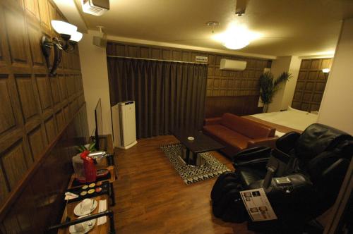 uma vista para uma sala de estar com um sofá e um quarto com uma cama em Hotel Dio (Adult Only) em Osaka