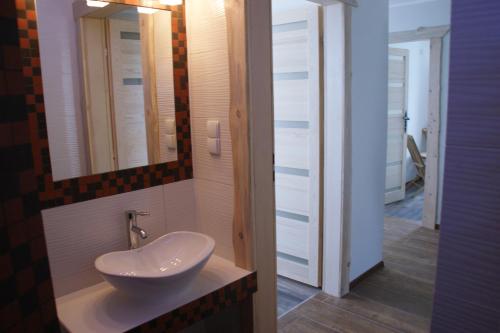 a bathroom with a sink and a mirror at Gama Spa in Władysławowo