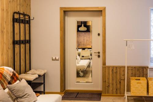 a living room with a door and a mirror at Solov'inaya Apartments in Gomel