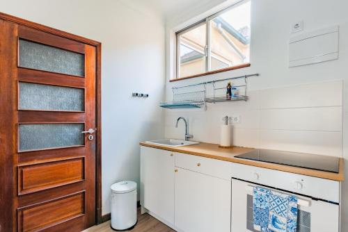 een kleine keuken met een wastafel en een deur bij Riverside City Centre Apartments in Porto