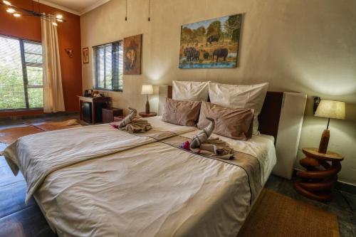 een slaapkamer met een groot bed met schoenen erop bij Ijaba Lodge at Buschfeld Park in Outjo