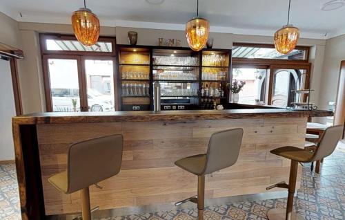 eine Bar mit 3 Stühlen und einer Holztheke in der Unterkunft Hotel Restaurant zum Schwanen in Bruchköbel