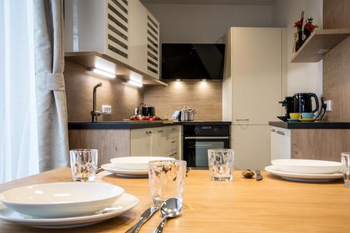 a kitchen with a wooden table with plates and glasses at Haus Lukic in Kaprun