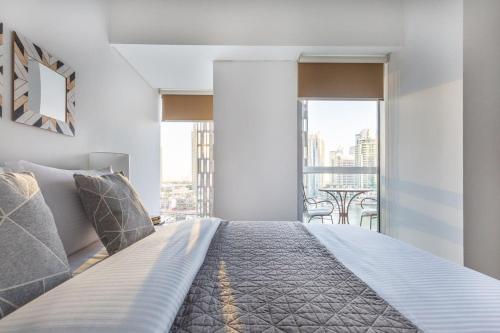 a bedroom with a large bed with a large window at Astonishing 1BR in Fabulous Cayan Tower in Dubai
