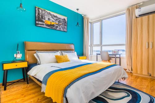 1 dormitorio con paredes azules y 1 cama con manta amarilla en Qingdao Huangdao·Qingdao Silver Beach·, en Qingdao