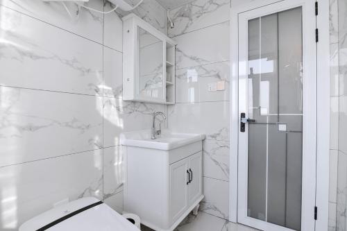 a white bathroom with a sink and a toilet at Luoyang Luolong·Dazhao International Plaza in Luoyang