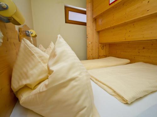 two twin beds in a room with wooden walls at Appartements Popotnik in Faak am See