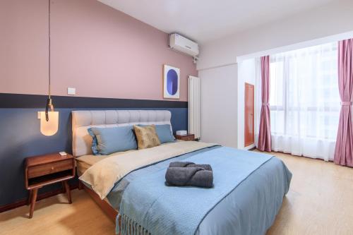 sypialnia z dużym łóżkiem i niebieskim kocem w obiekcie Tianjin·Hedong district·Excellence Building w mieście Tiencin