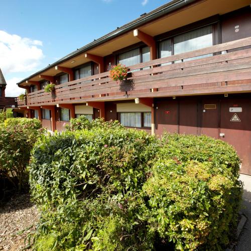 a building with bushes in front of it at Campanile Rouen Nord - Mont-Saint-Aignan in Mont-Saint-Aignan