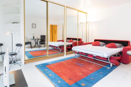 uma sala de estar com duas camas e um espelho em Studio à deux pas du Palais des Festivals em Cannes