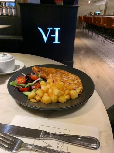 a plate with a sandwich and vegetables on a table at The Village Hotel, Bar and Restaurant in Bettystown