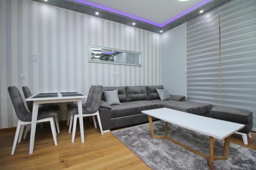 een woonkamer met een bank en een tafel bij NK18 Apartments in Zlatibor