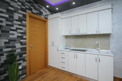 een keuken met witte kasten en een houten deur bij NK18 Apartments in Zlatibor