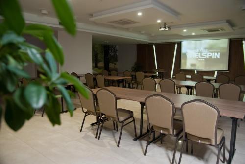 a conference room with a table and chairs and a screen at Wielspin Puszczykowo in Puszczykowo
