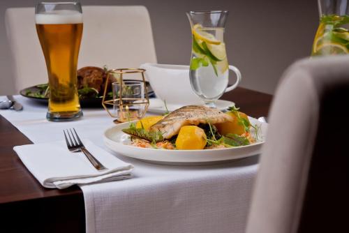 a plate of food on a table with a glass of beer at Wielspin Puszczykowo in Puszczykowo