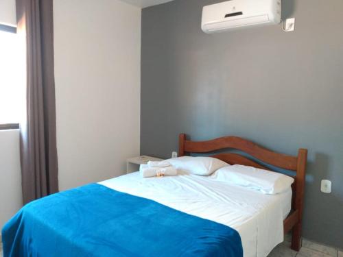 a bedroom with a bed with a blue blanket at Pousada Nilza Mar in Maceió