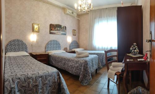 菲烏米奇諾的住宿－希拉里旅館，酒店客房设有两张床和窗户。