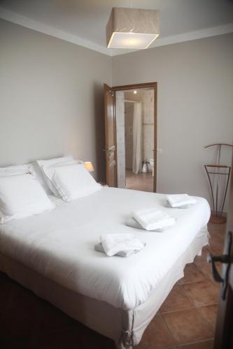 a large white bed with white pillows on it at La Maison De Maria in Folembray