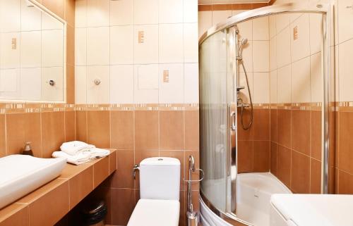 La salle de bains est pourvue de toilettes, d'une douche et d'un lavabo. dans l'établissement MIZU Apartamenty - Zielone Tarasy, à Kołobrzeg