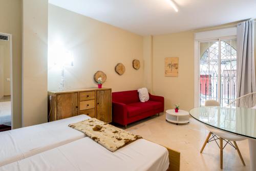 um quarto com um sofá vermelho e uma cadeira vermelha em GR0-Quiet apartment, Private backyard, Walk to Old Town em Málaga