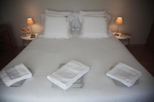 a large white bed with white pillows and towels at La Maison De Maria in Folembray