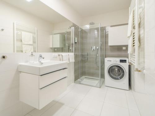 a white bathroom with a washing machine and a washer at Apartamenty Beach Life 5 Mórz in Sianozety