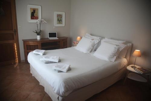 a bedroom with a white bed with two towels on it at La Maison De Maria in Folembray