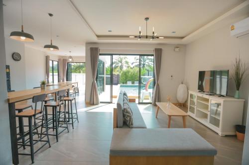 a kitchen and living room with a couch and a bar at Aonang nine poolvilla in Ao Nang Beach