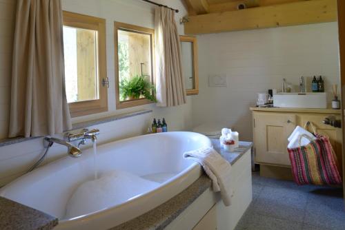 baño con bañera blanca y ventana en Chalet les Tissourds, en Chamonix-Mont-Blanc