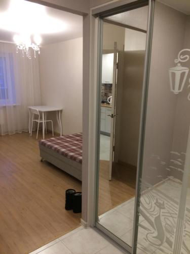 a sliding glass door leading to a room with a bed at Apartment on 2-Y Khlynovskiy Pereulok 1 in Kirov