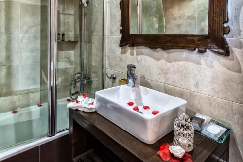 
a bath tub sitting next to a sink in a bathroom at El Tiburon Boutique Hotel & Spa (Adults Recommended) in Torremolinos
