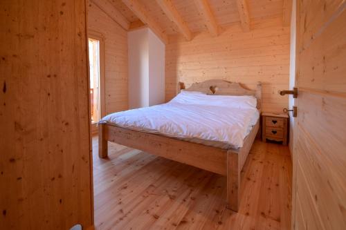 een slaapkamer met een bed in een houten kamer bij Chalet Le Cerf - Newly build - WOW Views! in La Tzoumaz