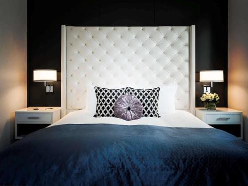 a bedroom with a large bed with a purple pillow at Sofitel Lafayette Square Washington DC in Washington