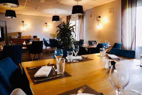 a restaurant with a large wooden table and chairs at Sure Hotel by Best Western Châteauroux in Le Poinçonnet