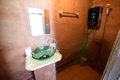 La salle de bains est pourvue d'un lavabo vert et d'une douche. dans l'établissement Mon Hmong, à Chiang Mai