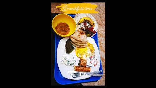 a blue tray with a plate of breakfast food at Cheers Hostel in Cairo