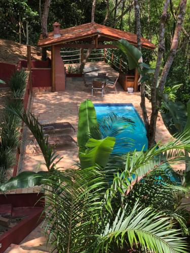 einen Hinterhof mit einem blauen Pool und einem Pavillon in der Unterkunft Casa Rossa Bungalows & Apartments in Morro de São Paulo