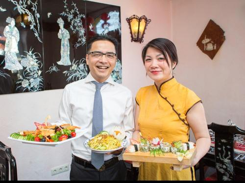 a man and a woman holding plates of food at Gasthaus Pavillon in Dresden