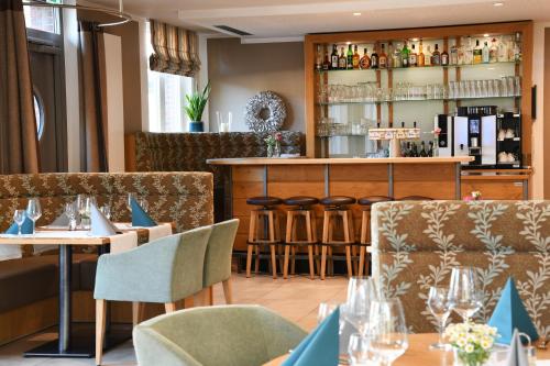 een restaurant met tafels en stoelen en een bar bij Hotel Am Markt in Heek