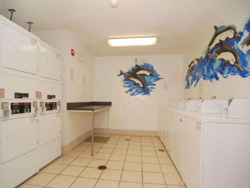 a kitchen with white cabinets and dolphins painted on the walls at Tampa Bay Extended Stay - Airport in Tampa