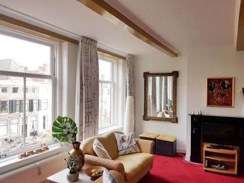 a living room with a couch and a large window at Large Historical Apartment & Canal Terrace in Utrecht