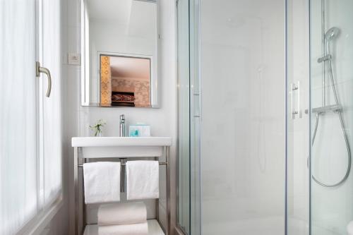 a white bathroom with a sink and a shower at Jardins Eiffel in Paris