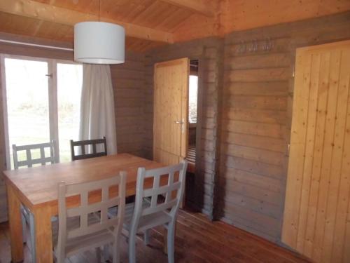a dining room with a wooden table and chairs at Vakantiepark t Urkerbos - Blokhutje in Urk