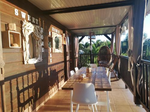 a porch with a table and chairs on it at Vanille Lodge in Le Marin