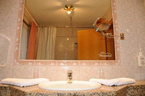 a bathroom with a sink and a mirror at Hotel Neuwirt in Brandenberg